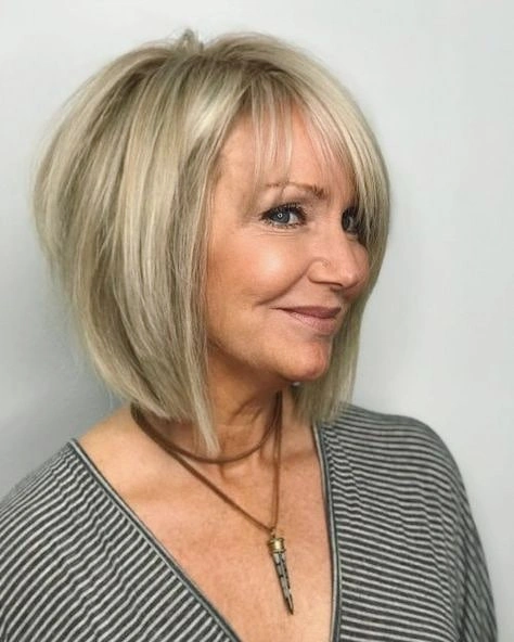 Blonde layered bob with wispy bangs and longer side pieces