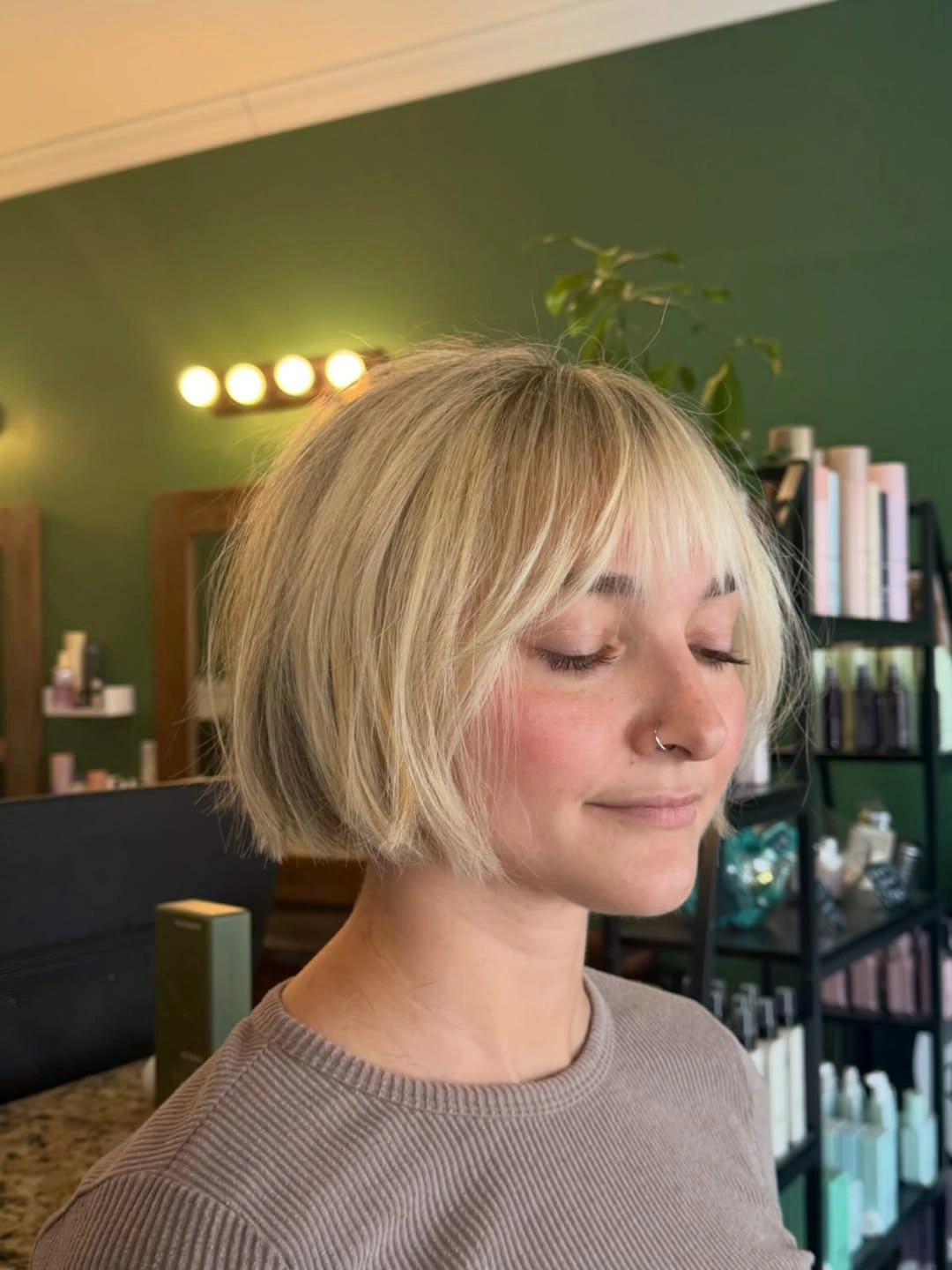 Short blonde bob with full bangs and curved ends
