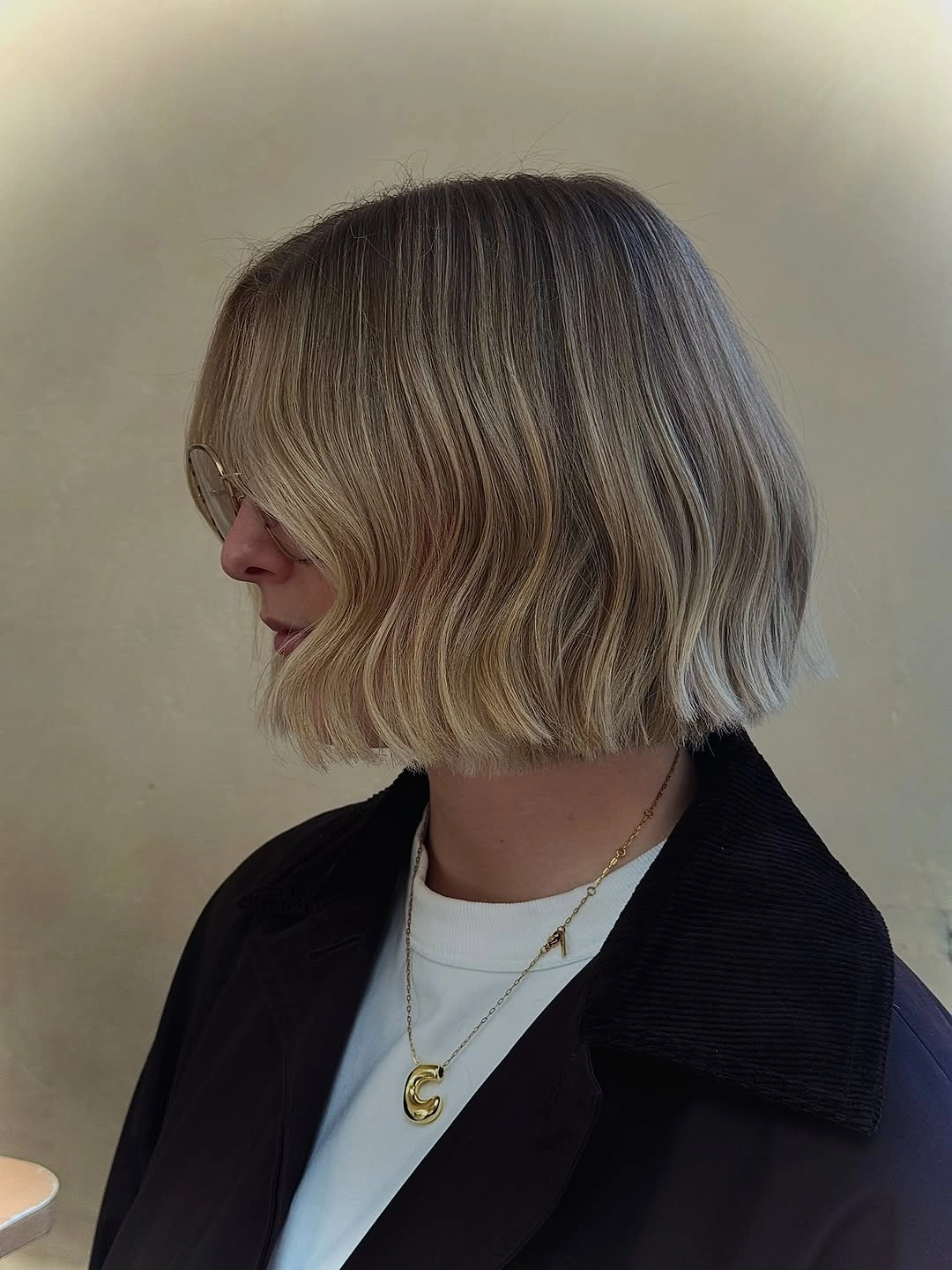 Wavy blonde jaw-length bob with darker roots and blunt edge