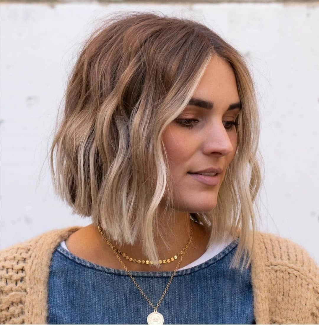 Wavy blonde lob with darker roots and bright front pieces