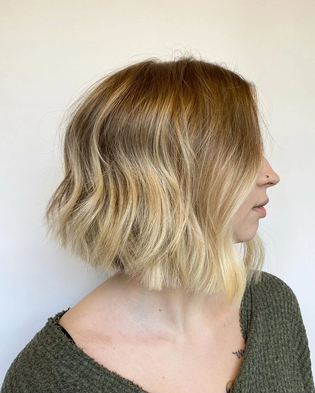 Layered blonde bob with darker roots and wavy longer front