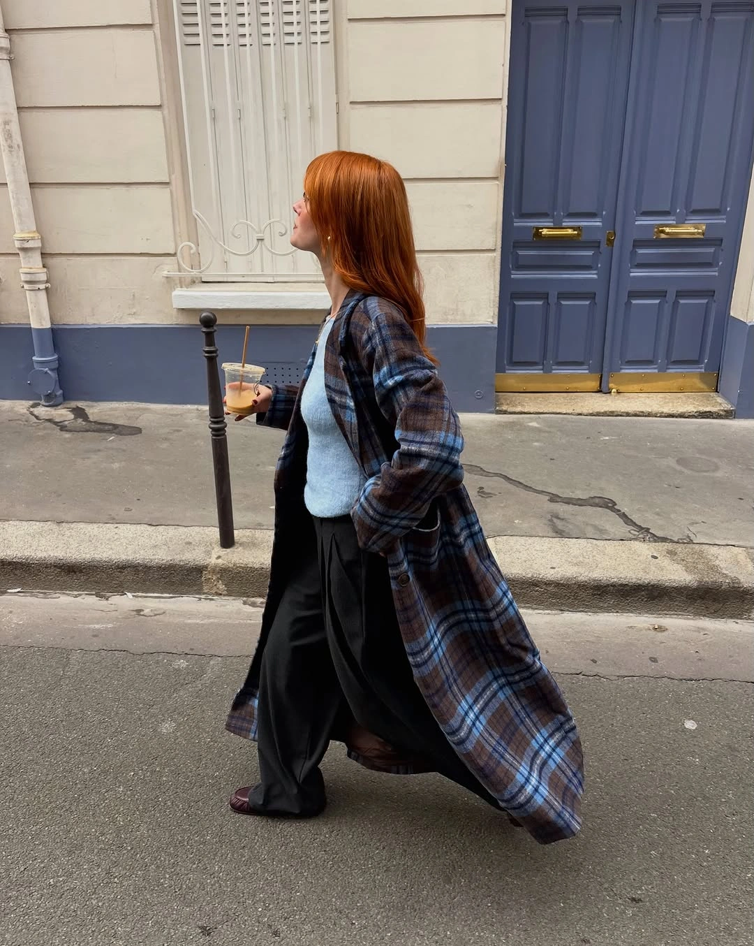 Long blue plaid coat with pale top and wide black trousers