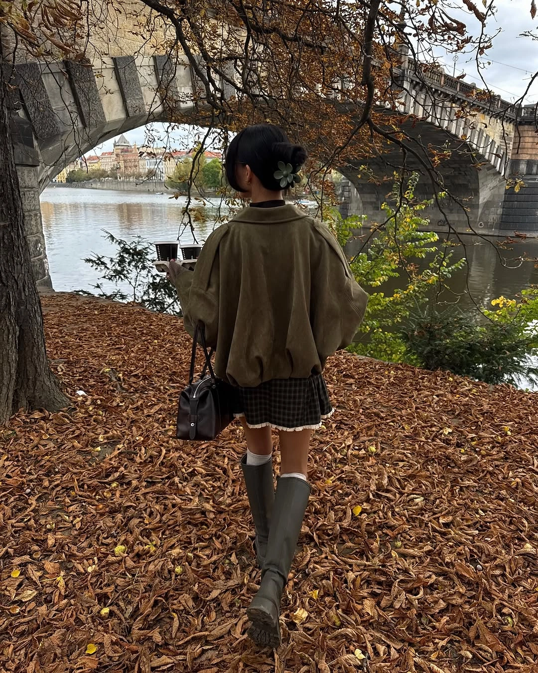 Oversized olive jacket with tall green boots and checked hem