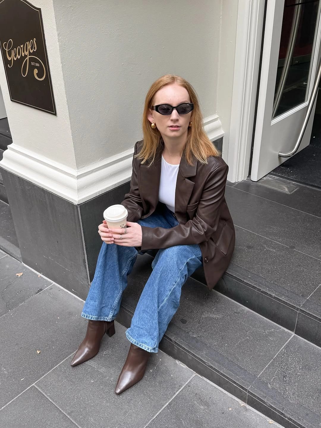 Dark brown blazer with blue jeans and pointed brown boots