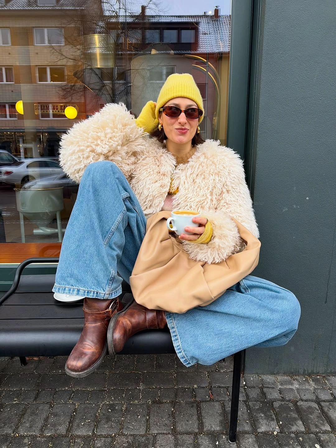 Yellow beanie with textured cream jacket and wide blue jeans