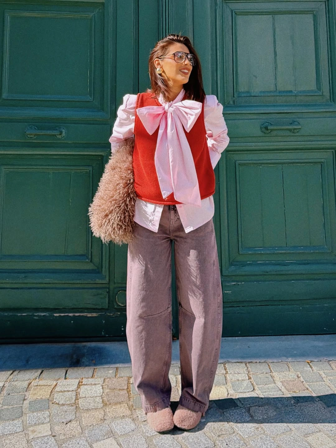 Pink bow blouse with red knit and wide muted trousers