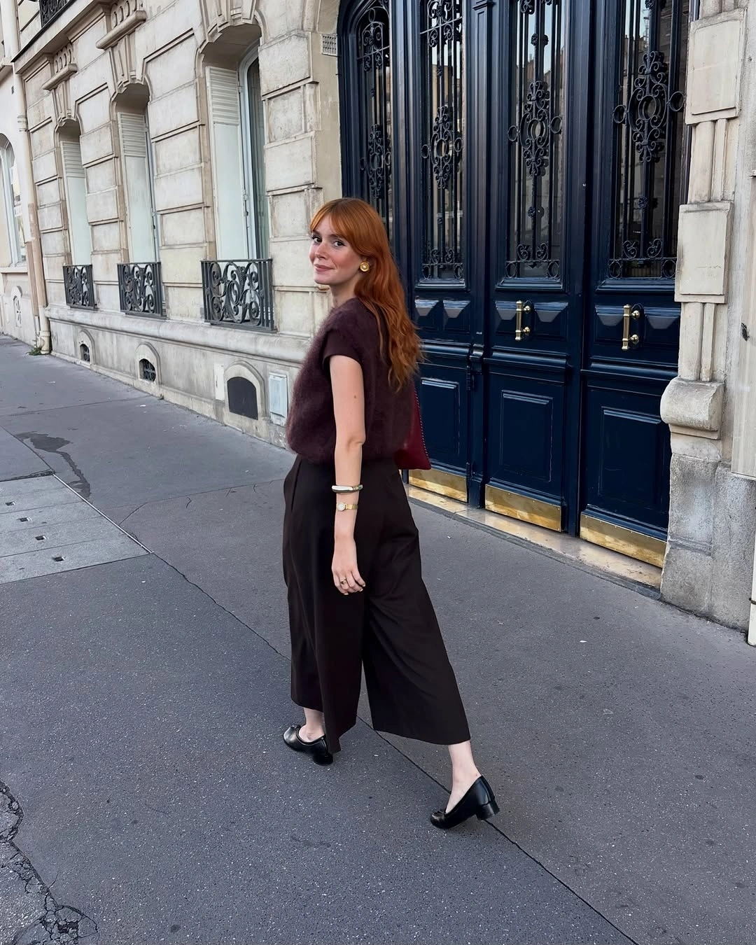 Dark burgundy sleeveless top with cropped black trousers and bow heels