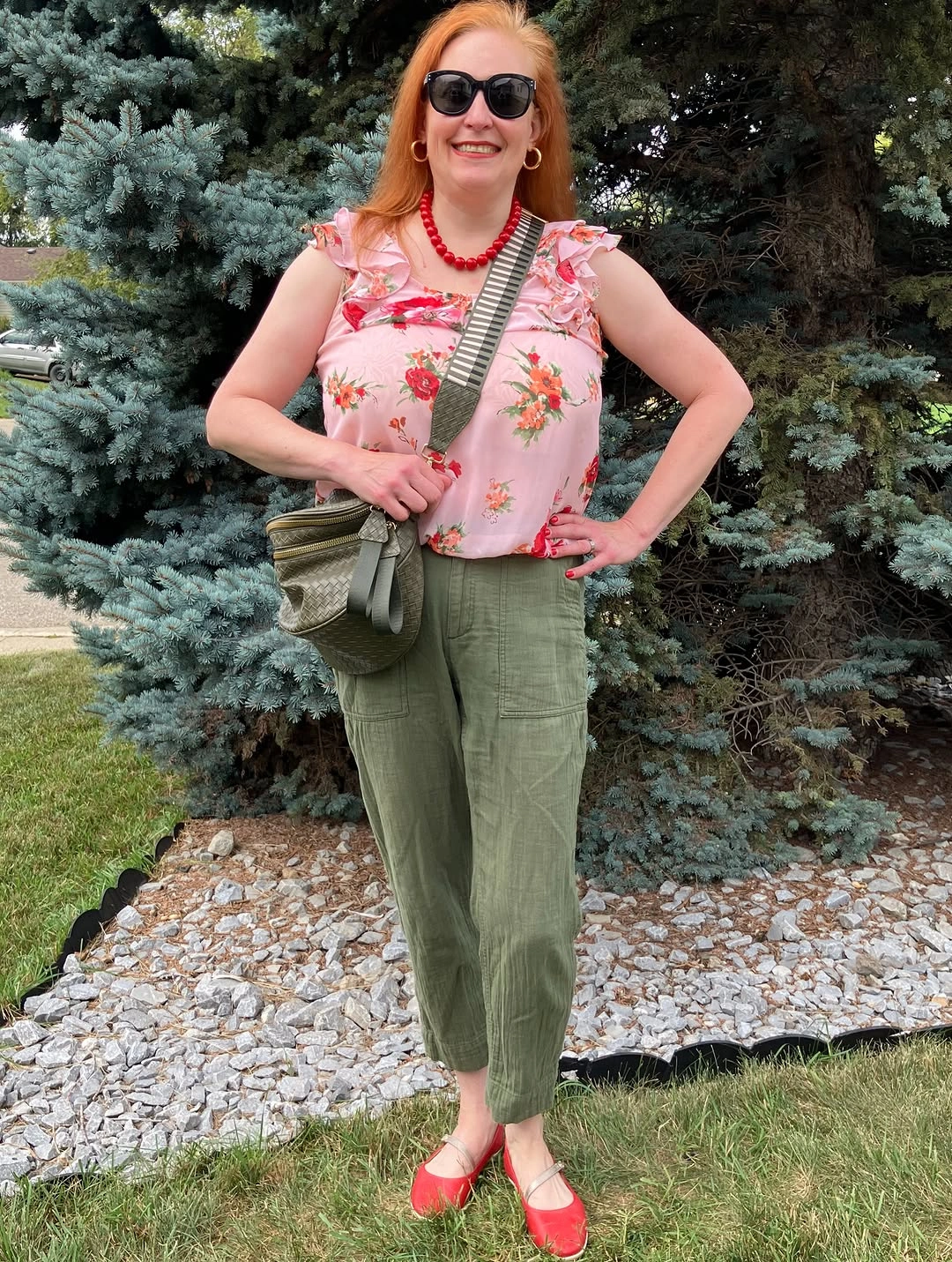 Woman in floral top olive pants and red flats