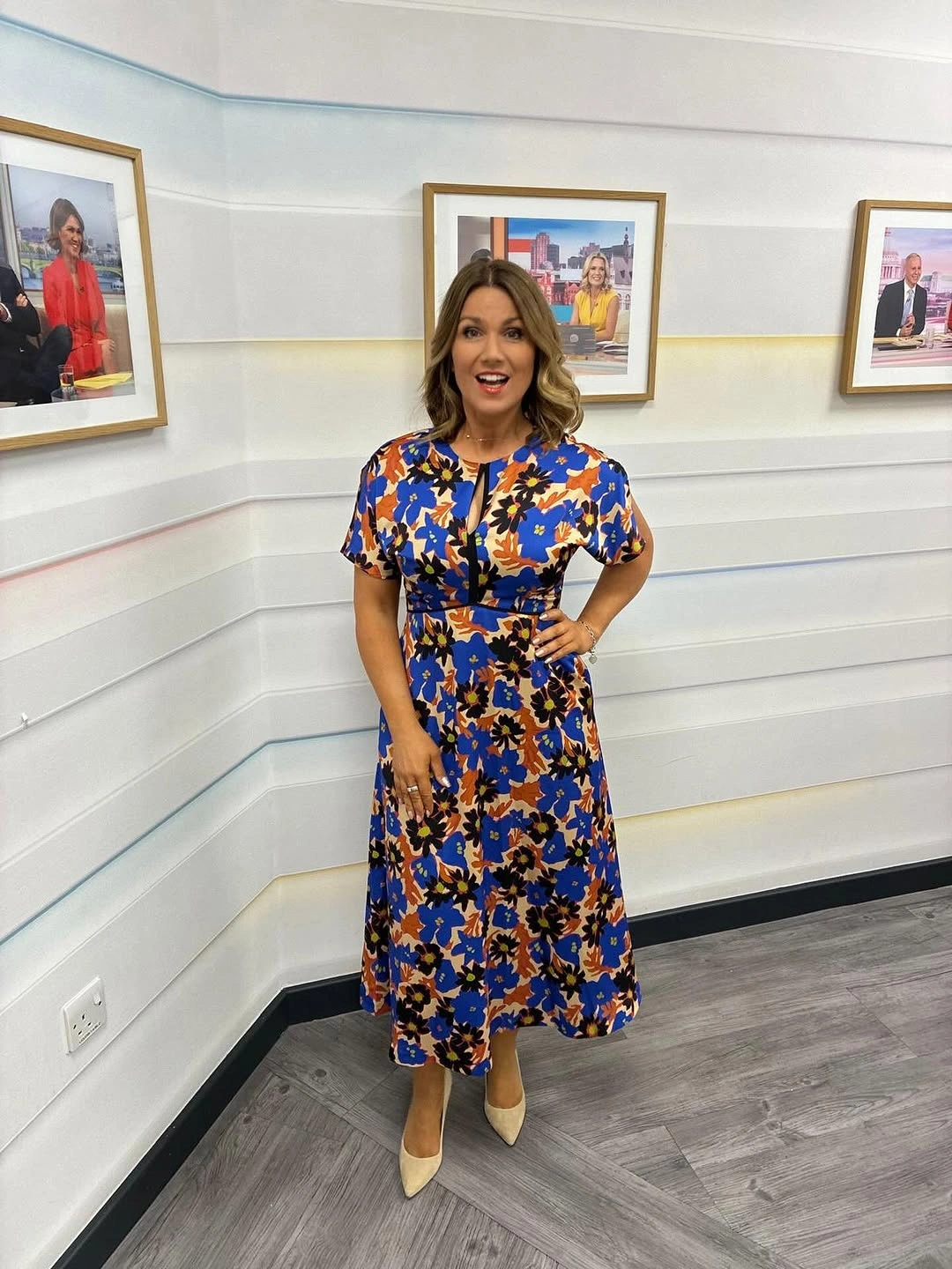 Woman wearing colorful floral midi dress and beige heels