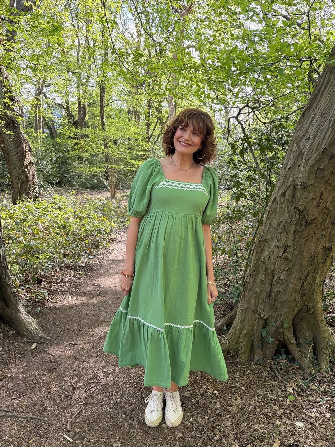 Woman in green puff sleeve dress and white sneakers