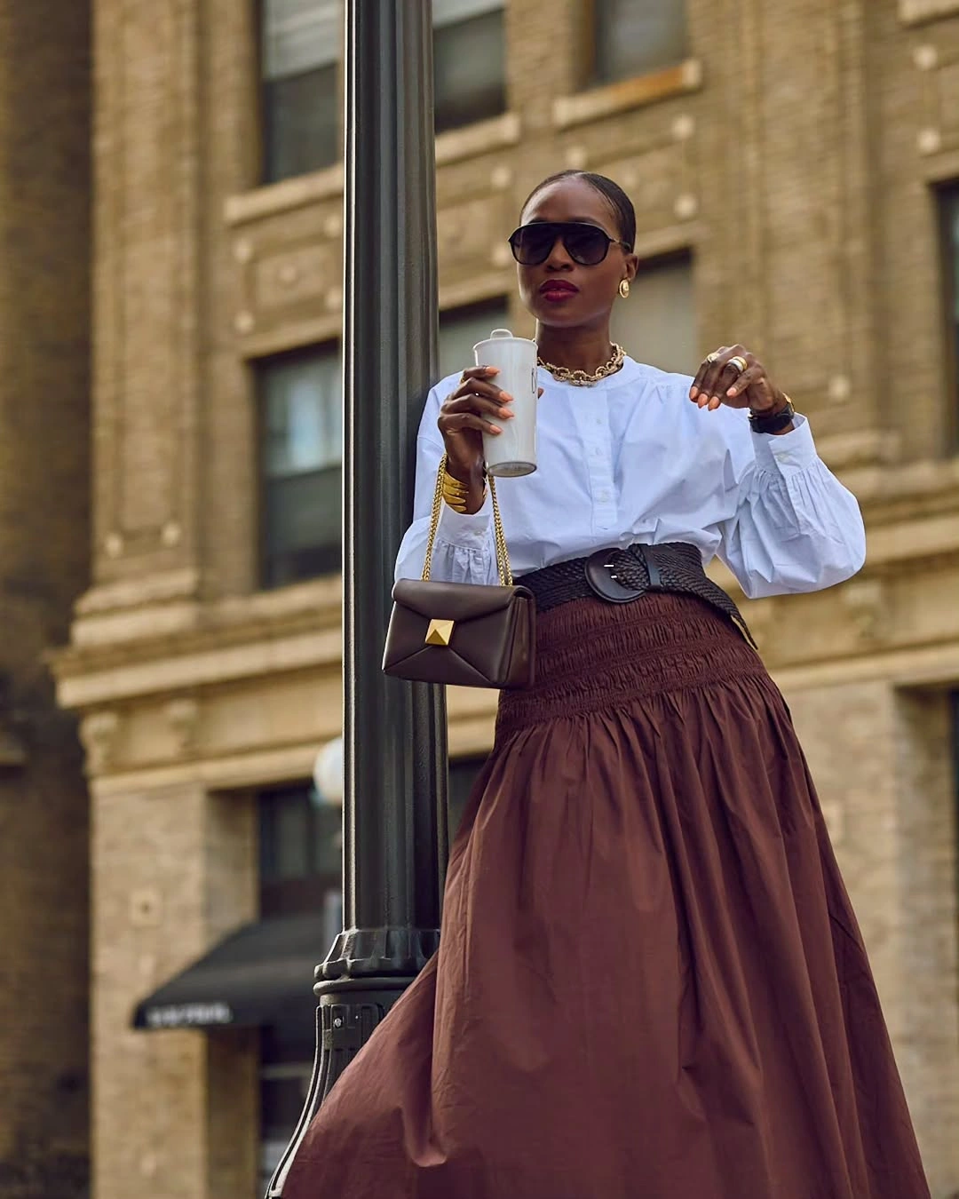 Woman in white blouse brown skirt and black belt