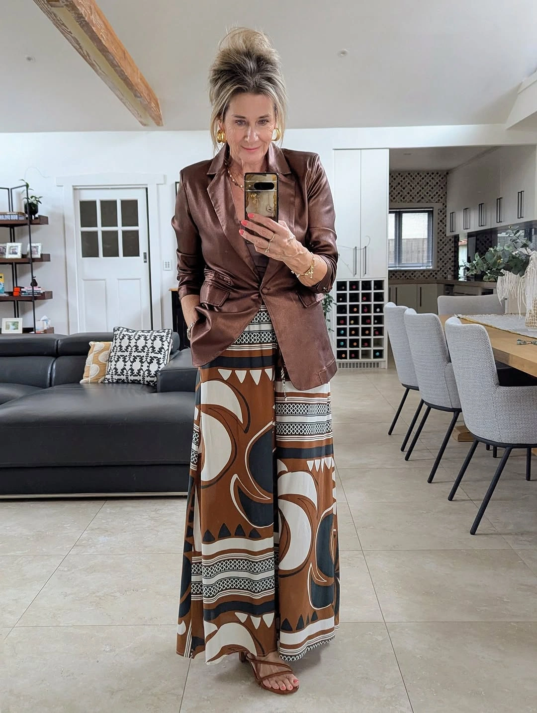 Woman in brown belted blazer and patterned skirt