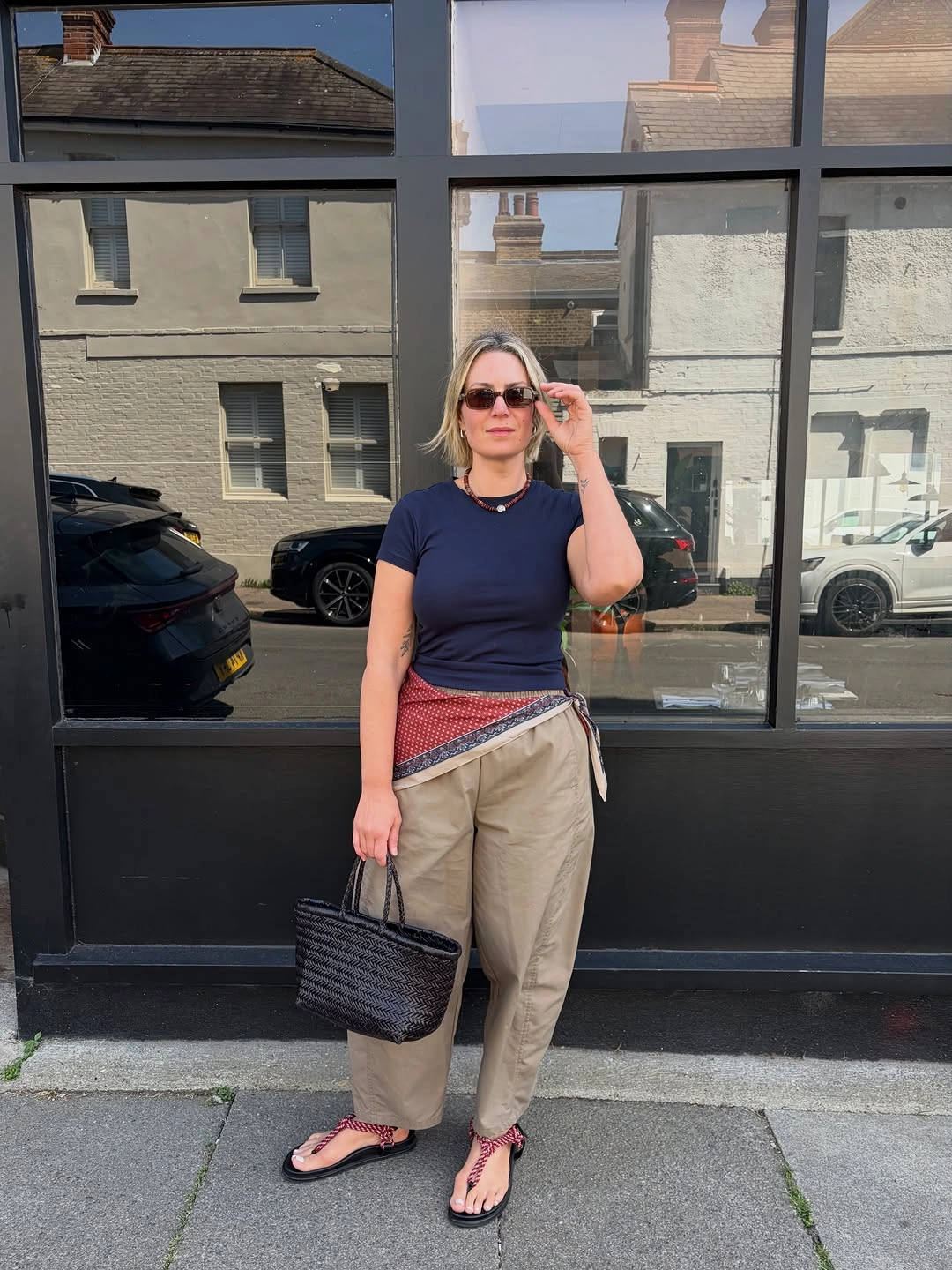 Navy T-shirt with khaki trousers and patterned waist scarf