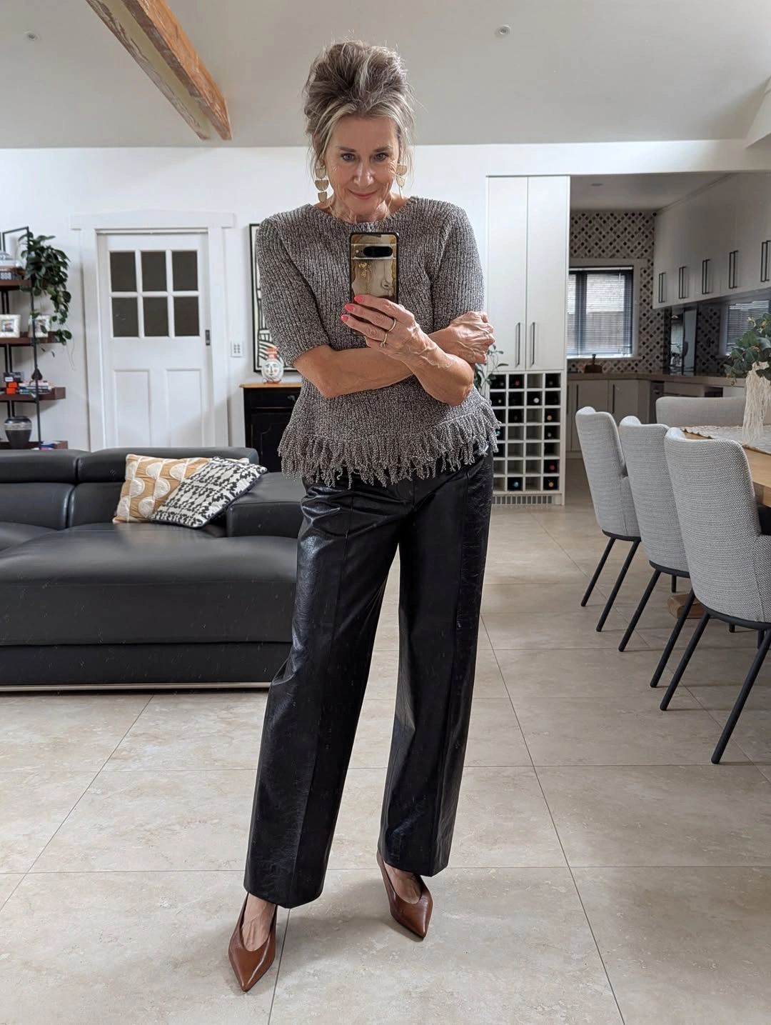 Gray fringed top with glossy black trousers and brown heels