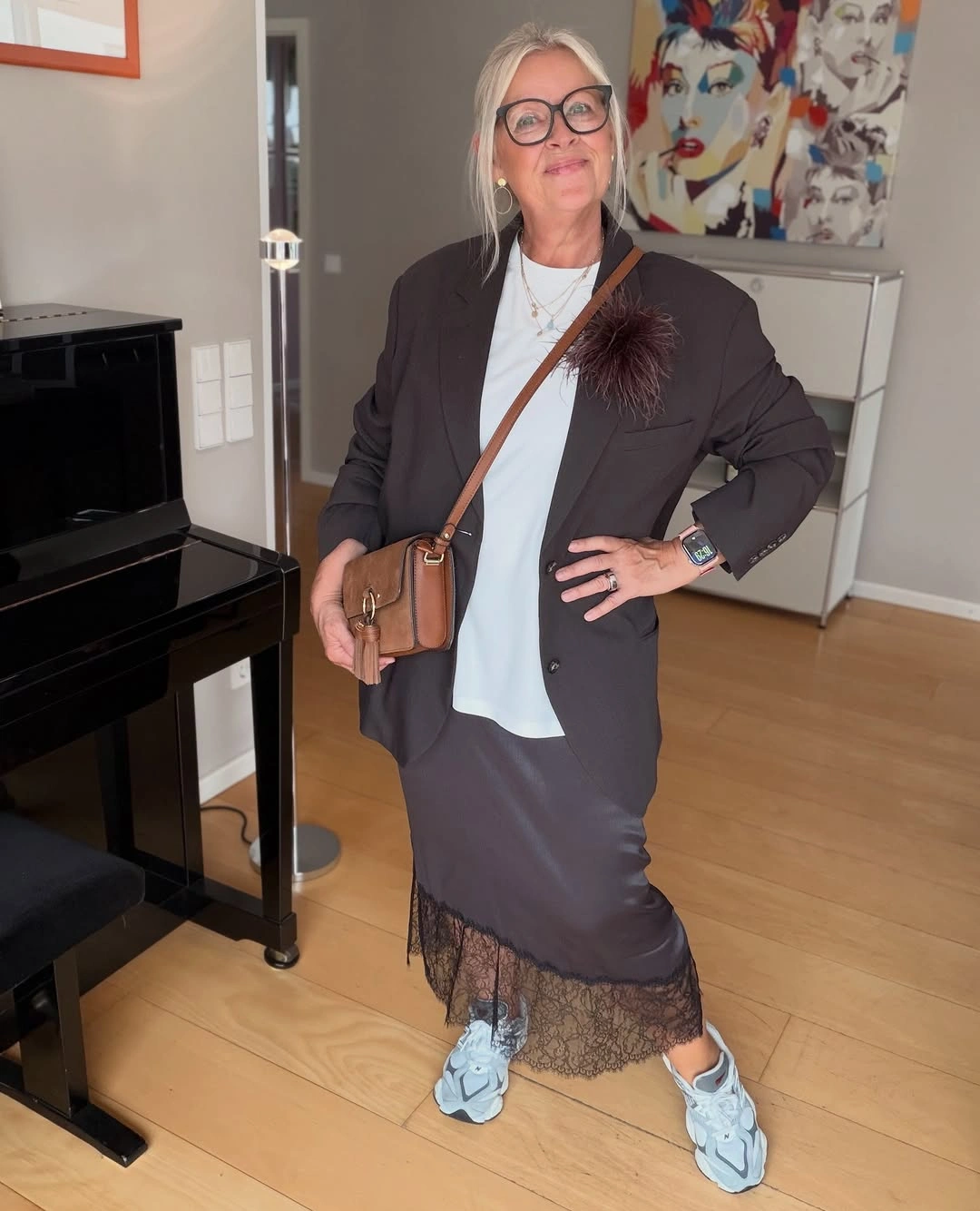 Dark blazer with lace hem skirt and pale sneakers