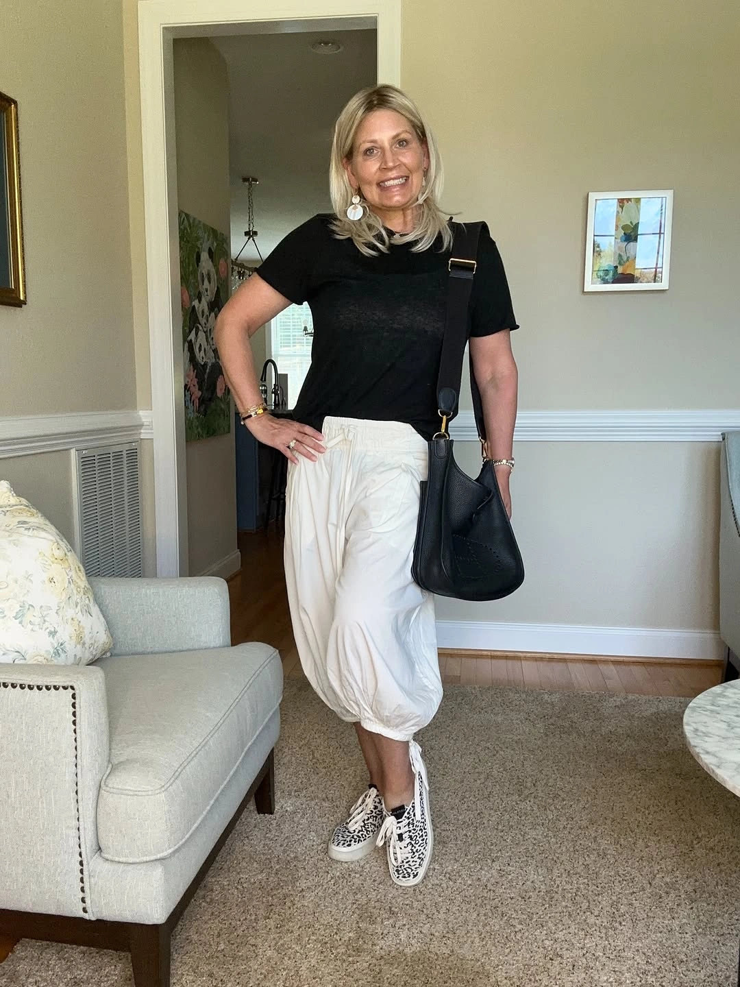 Black top with cream cropped pants and patterned sneakers