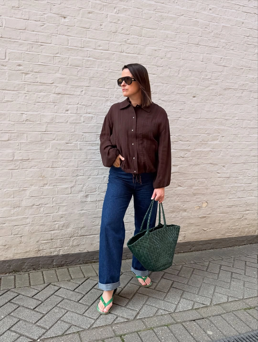 Brown button shirt with cuffed jeans and green tote