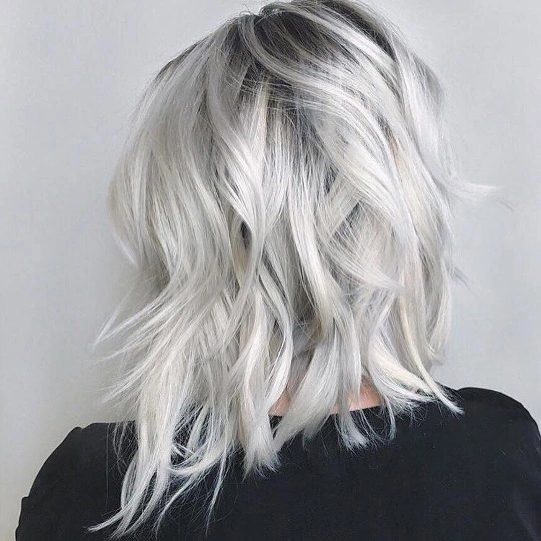 Wavy icy blonde bob with dark shadowed roots
