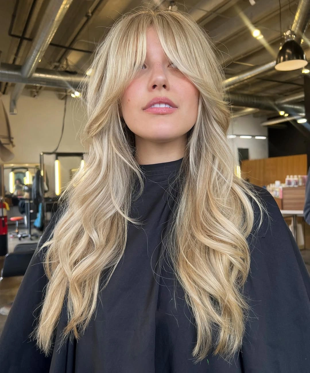 Long pale beige blonde with curtain bangs and waves
