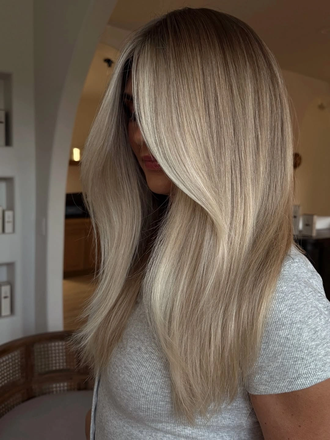 Long straight neutral beige blonde with deeper roots