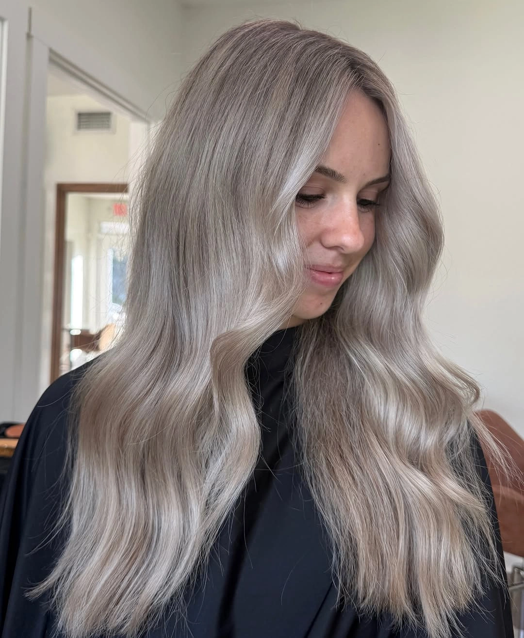 Long smoky ash blonde waves with muted cool depth