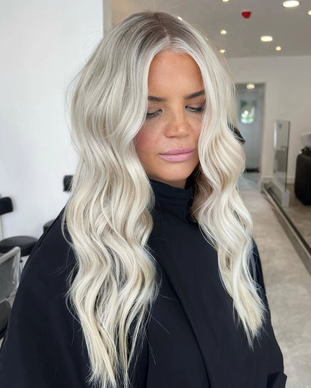 Long near-platinum blonde waves with soft root depth