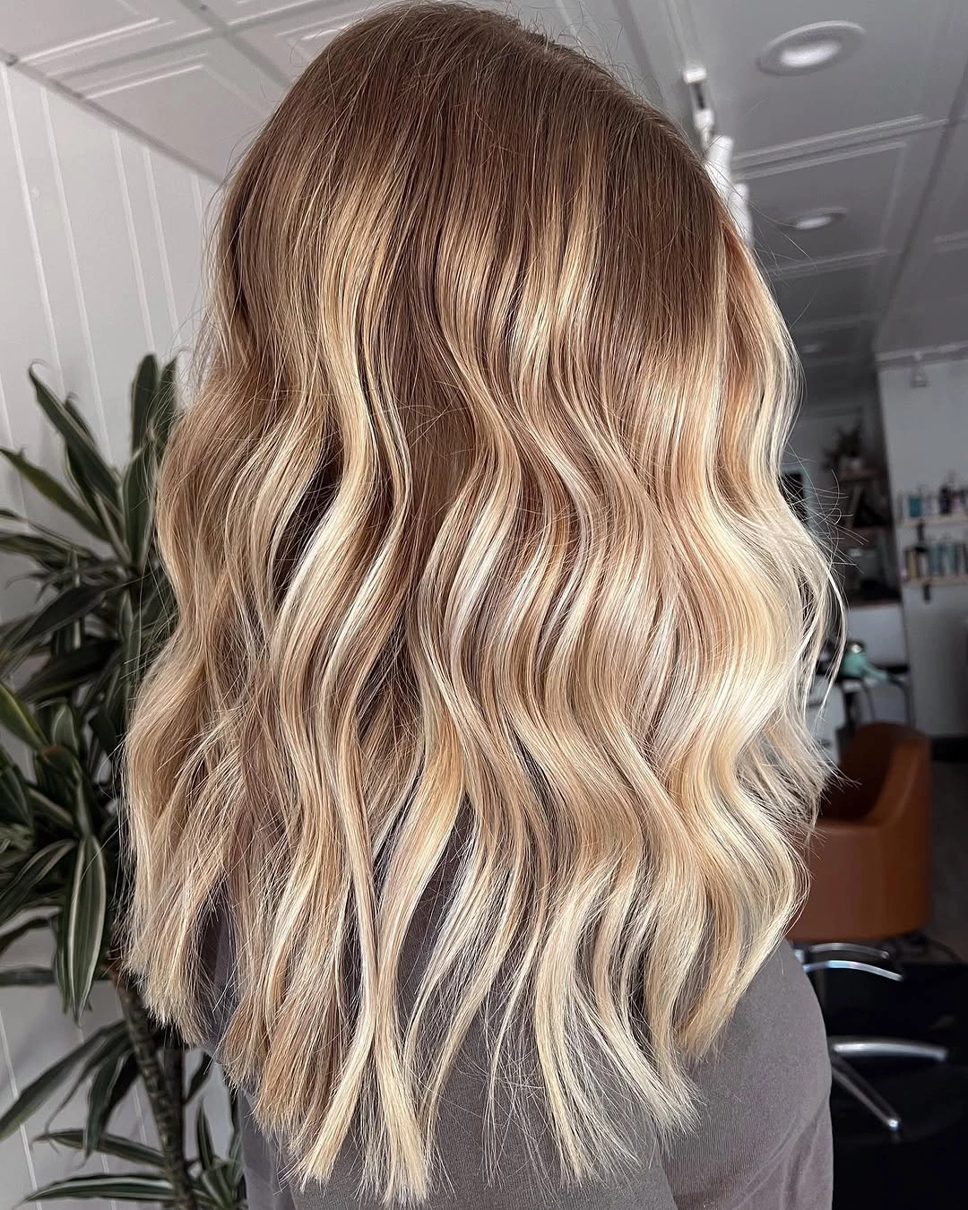 Warm blonde waves with caramel ribbons and deeper roots