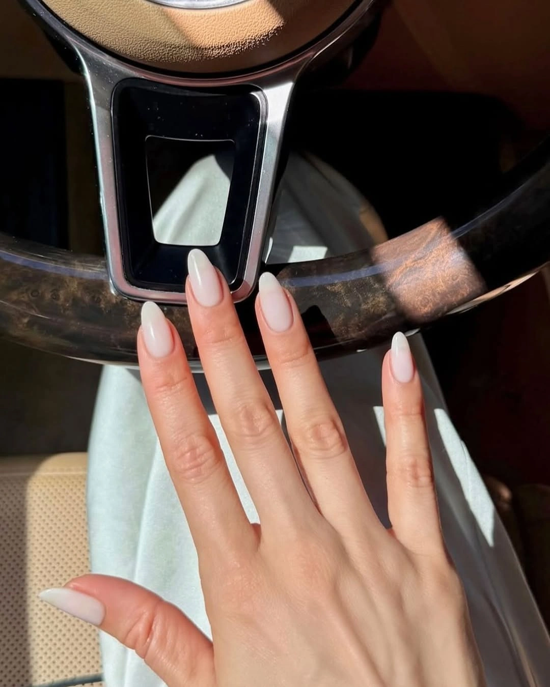 Soft white almond nails with pale base and glossy finish