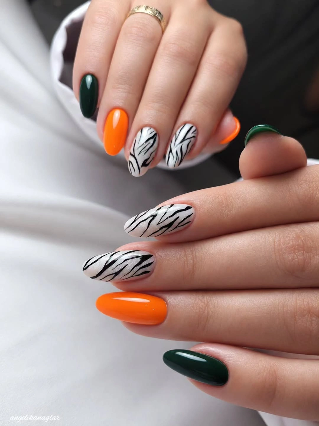 Orange green and striped white almond nails on both hands