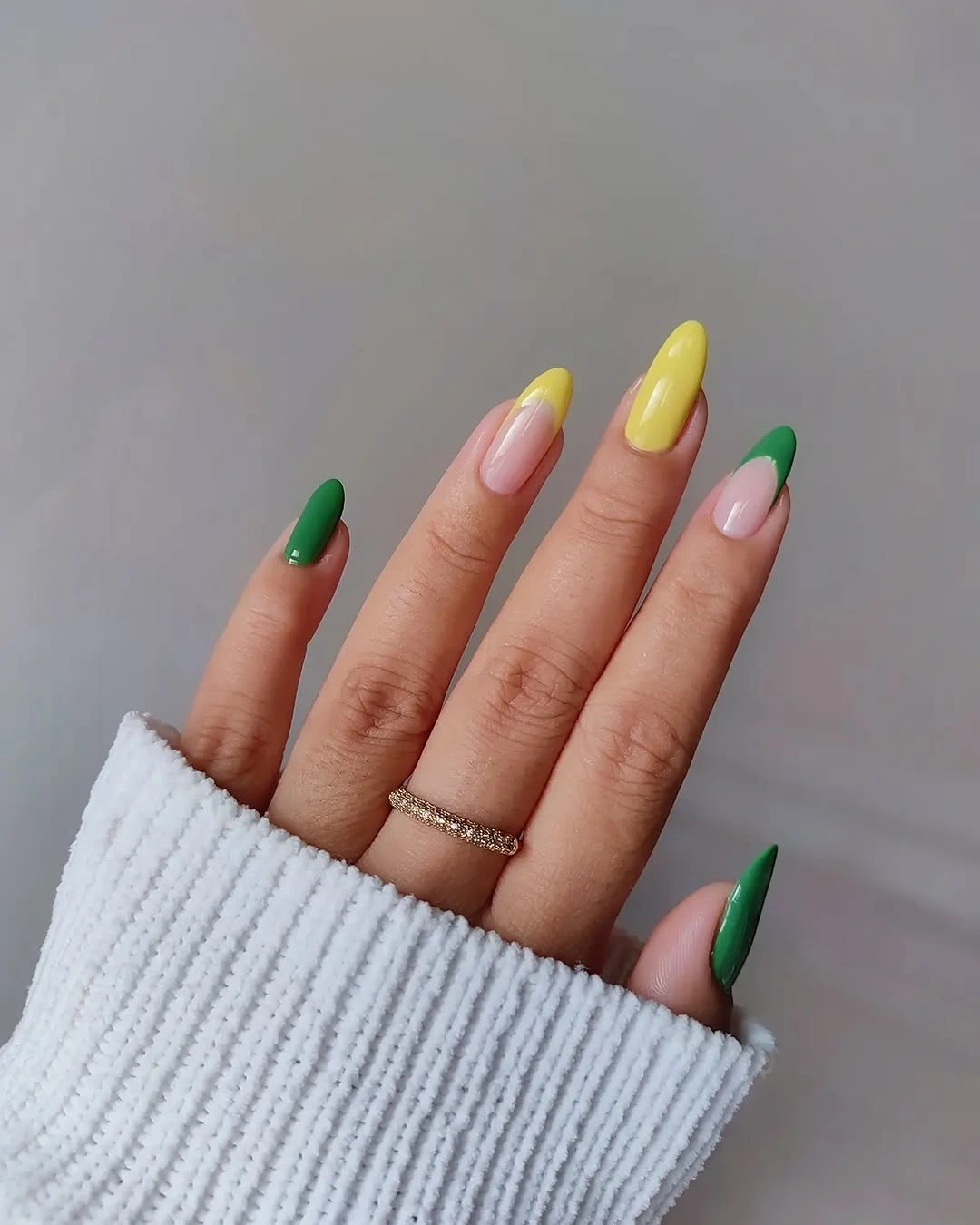 Green yellow and pale pink almond nails with angled tips