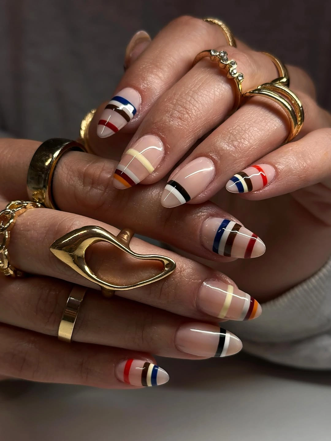 Nude almond nails with red navy black and cream stripes