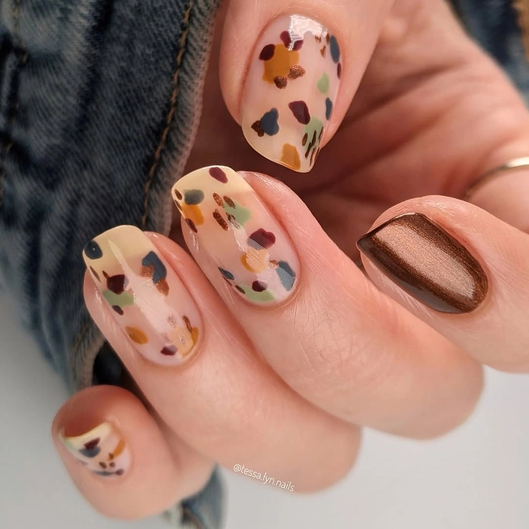 Short nude nails with multicolor spots and brown accent