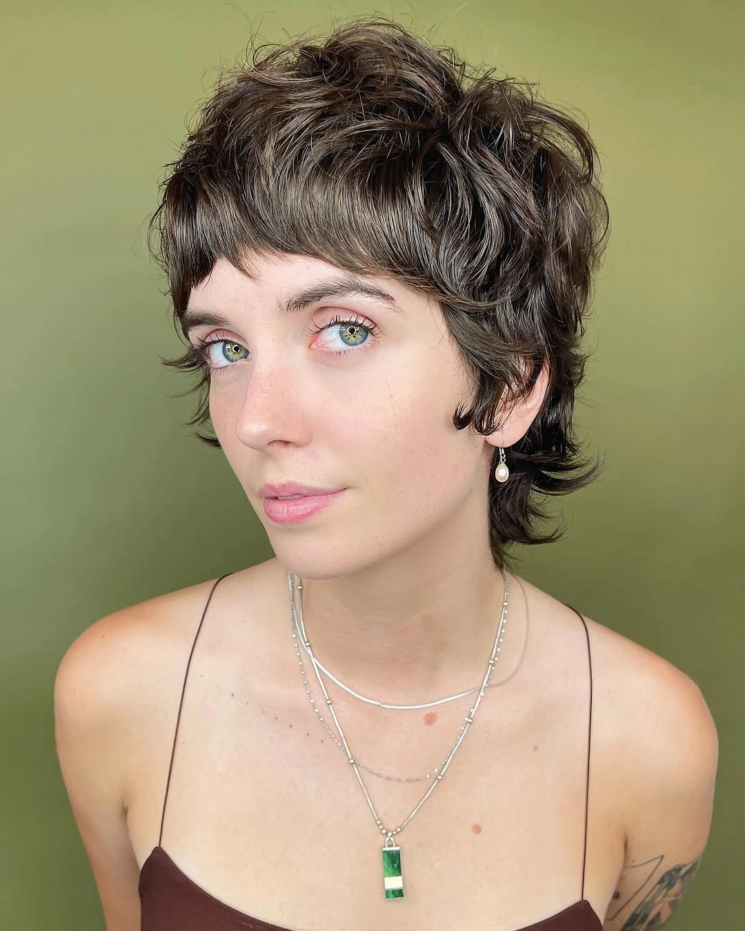 Short brown pixie-shag with choppy fringe and longer nape