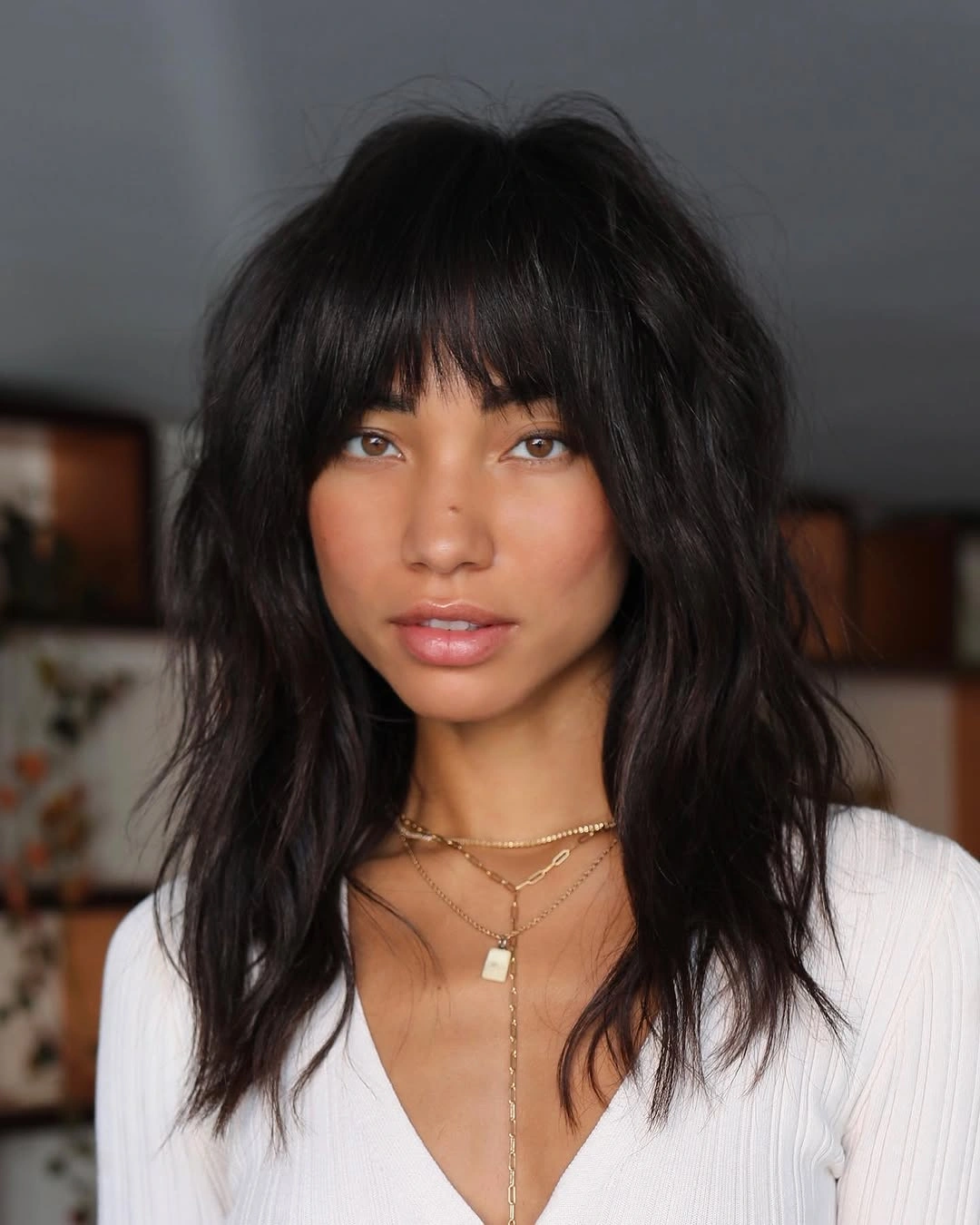 Black shoulder-length shag with full bangs and loose waves