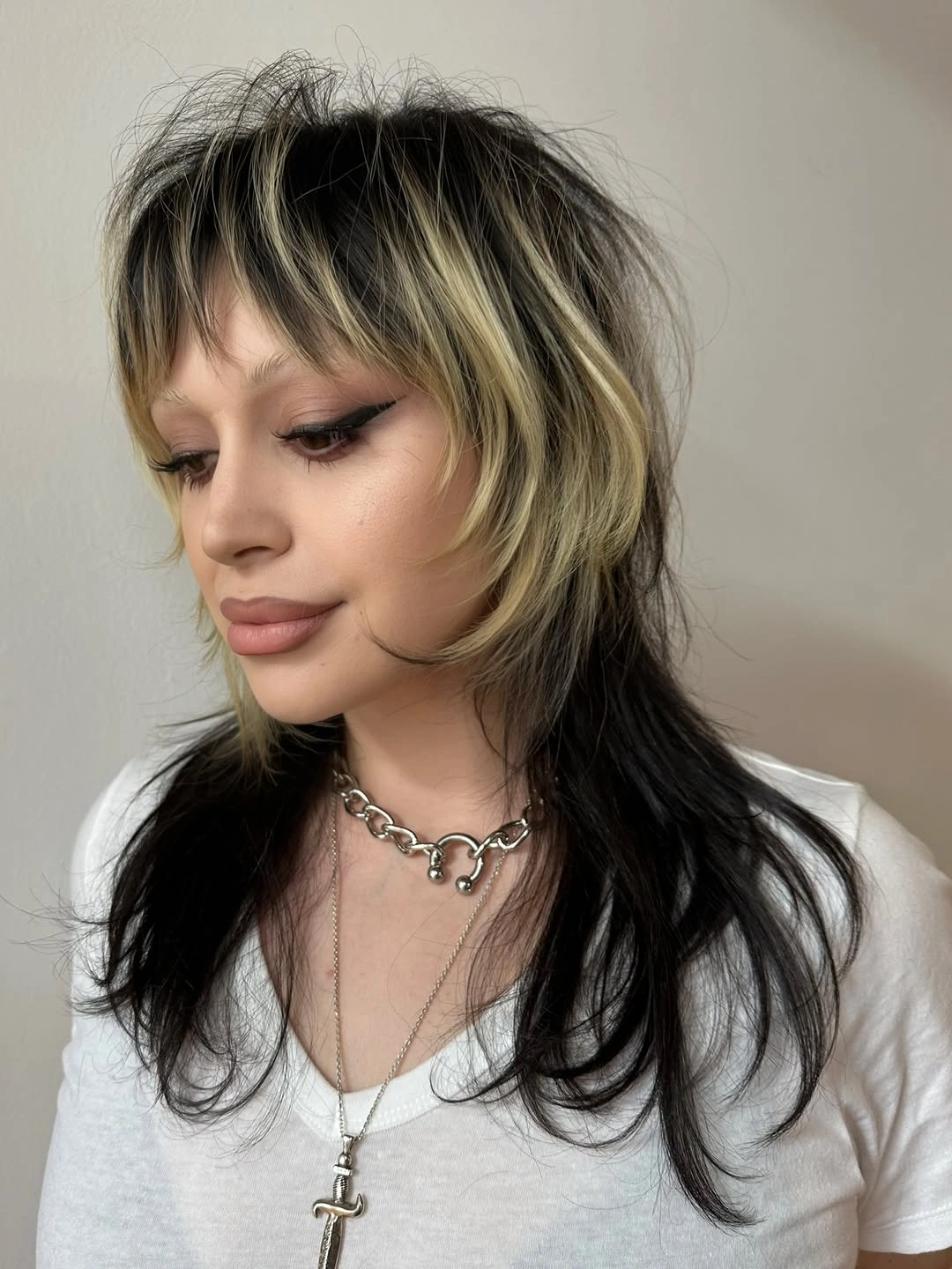 Black layered shag with blonde streaks and choppy bangs