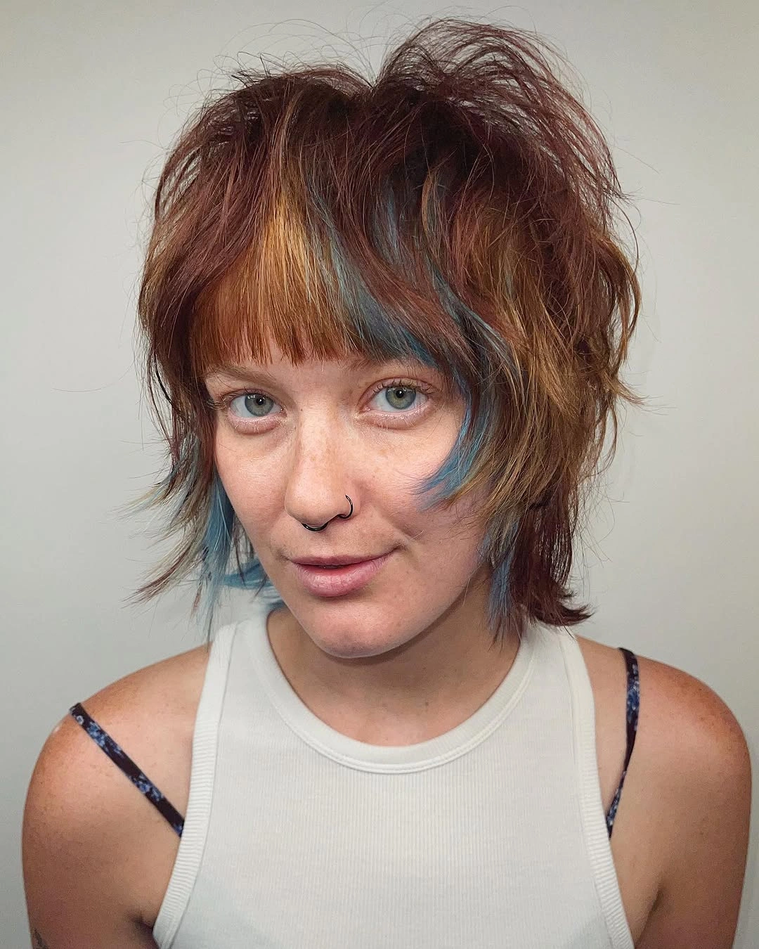 Short auburn shag with straight bangs and blue accents