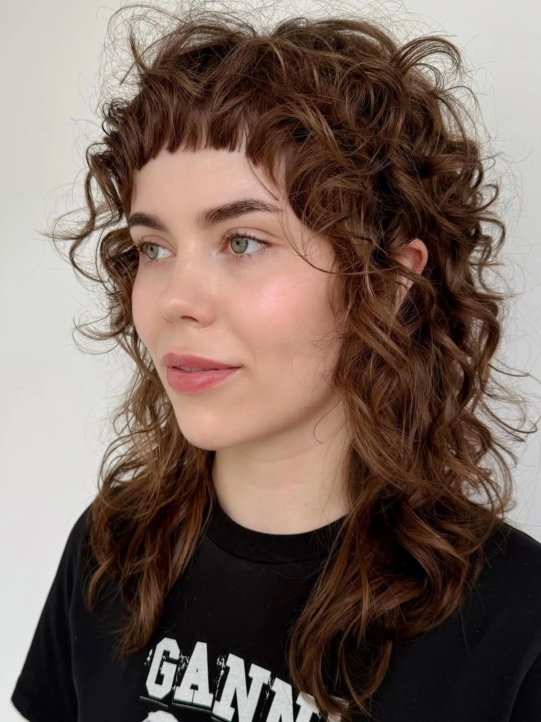 Curly brown shag with short bangs and shoulder-length layers