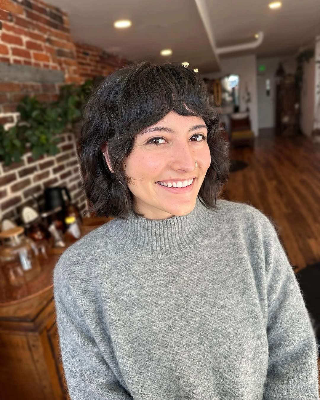 Short dark wavy bob with curved bangs
