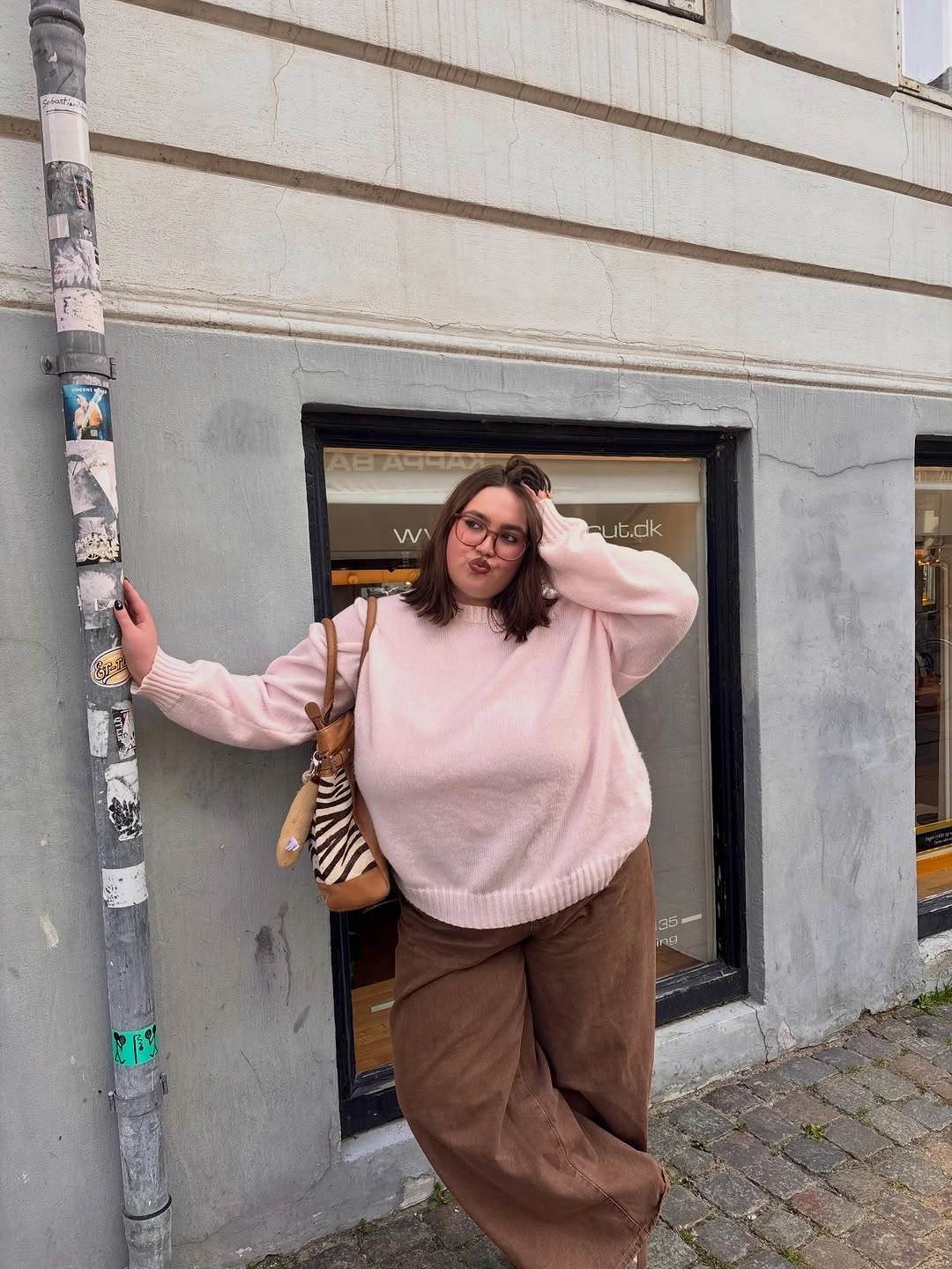 Shoulder-length brunette lob with glasses and pink sweater