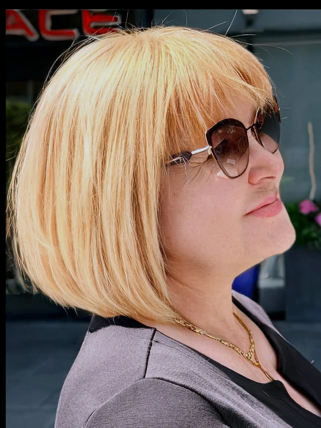 Smooth blonde bob with swept front and dark sunglasses