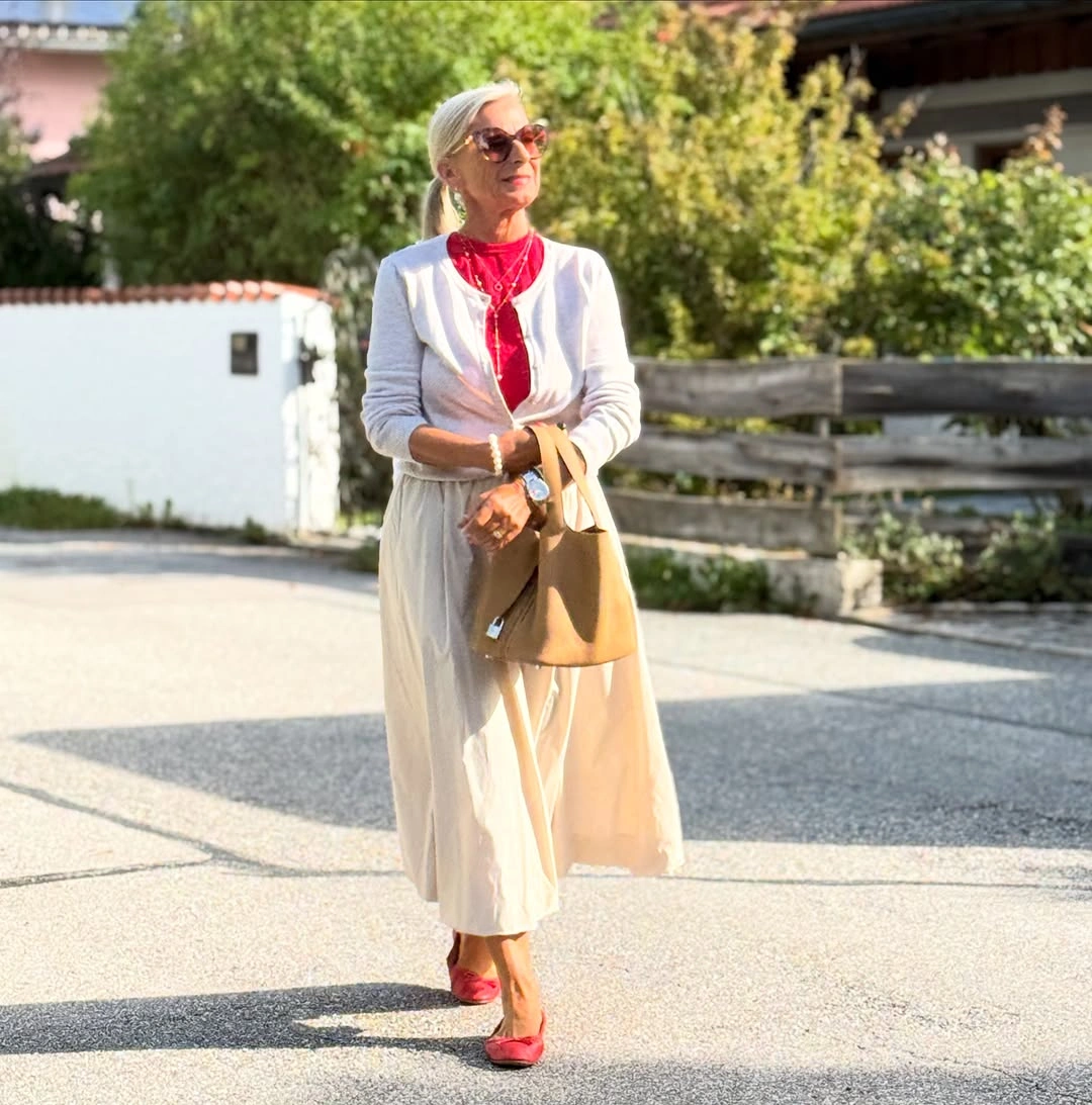 Cream cardigan with red neckline detail and red flats
