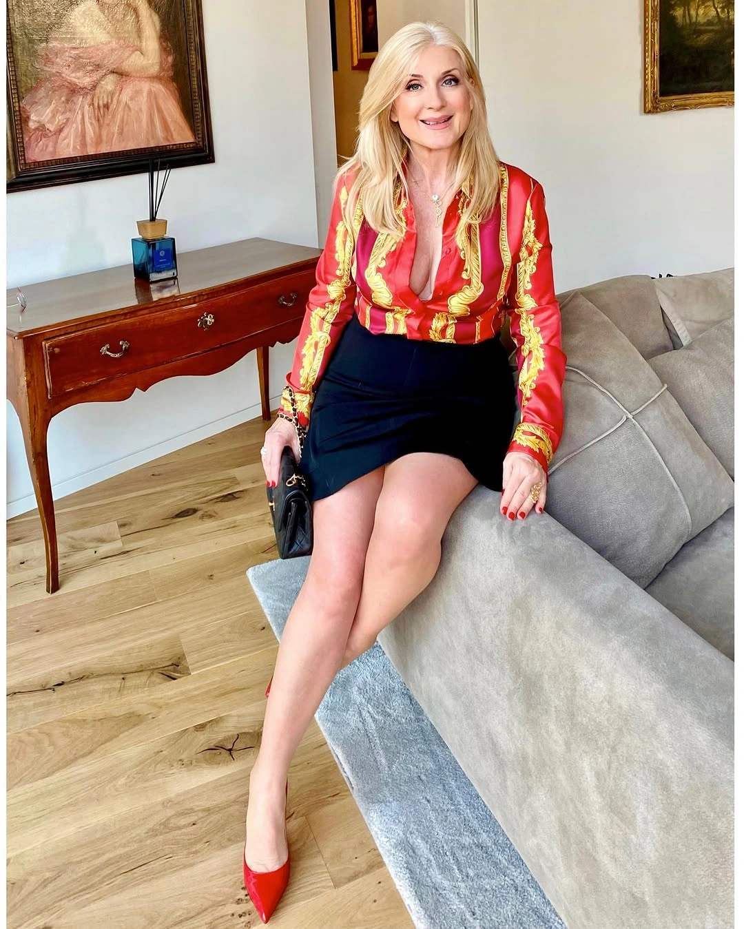 Shiny red patterned blouse with black skirt and red pumps