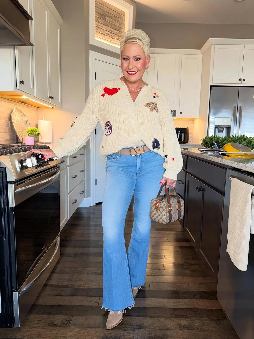 Cream patch cardigan with light flared jeans and handbag