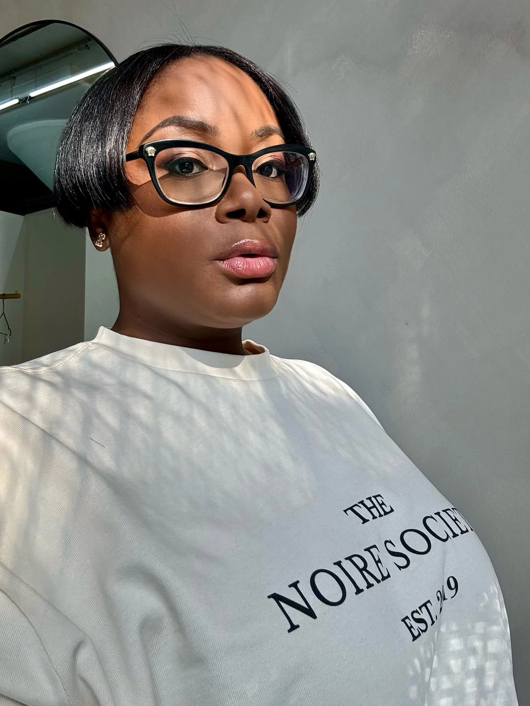 Sleek short bob with side part and black glasses