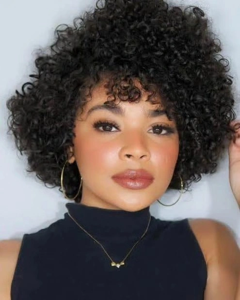 Short rounded curly cut with defined fringe and hoops