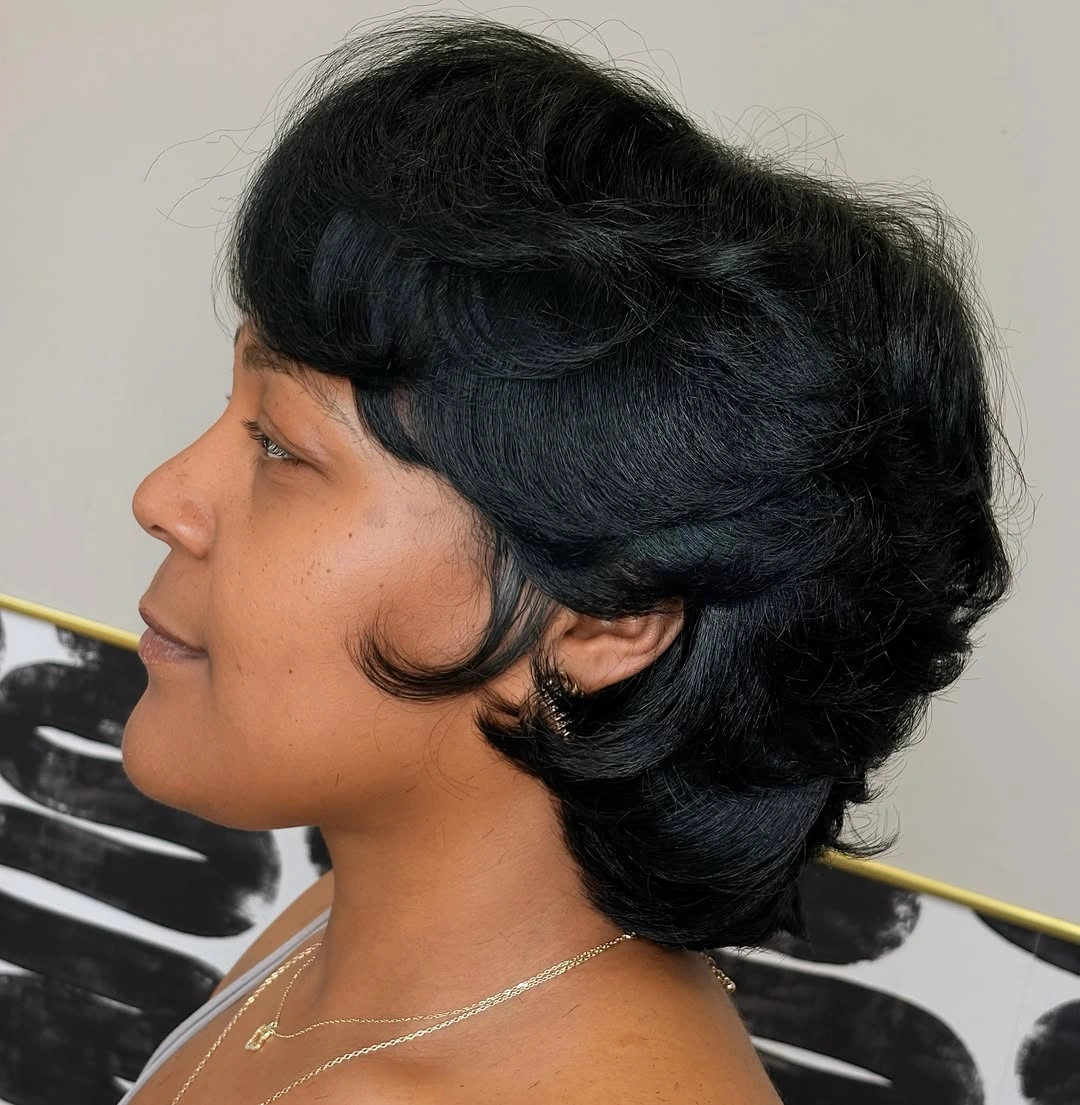 Layered short haircut with lifted crown and curled sideburns