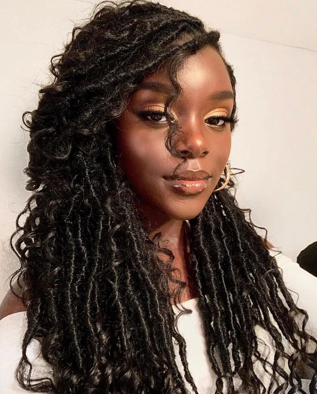 Long textured locs with side-swept crown and curled ends