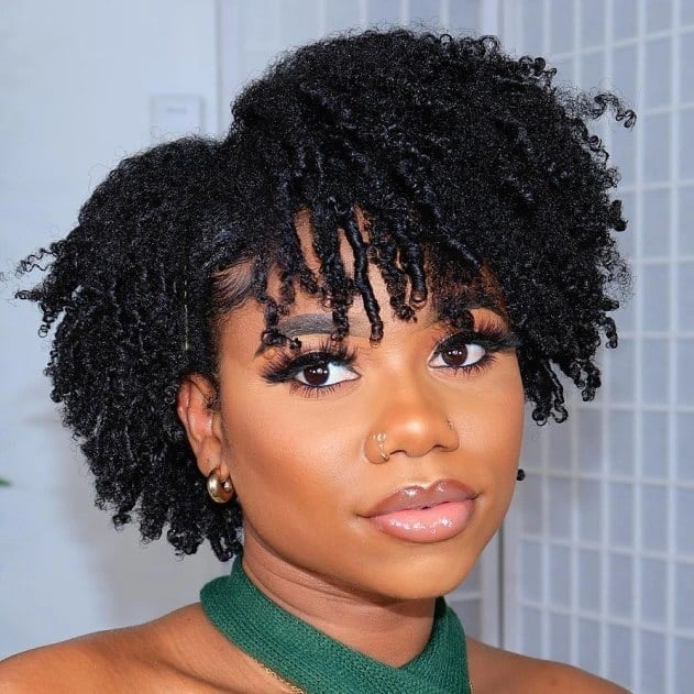 Short curly bob with dense bangs and green neckline