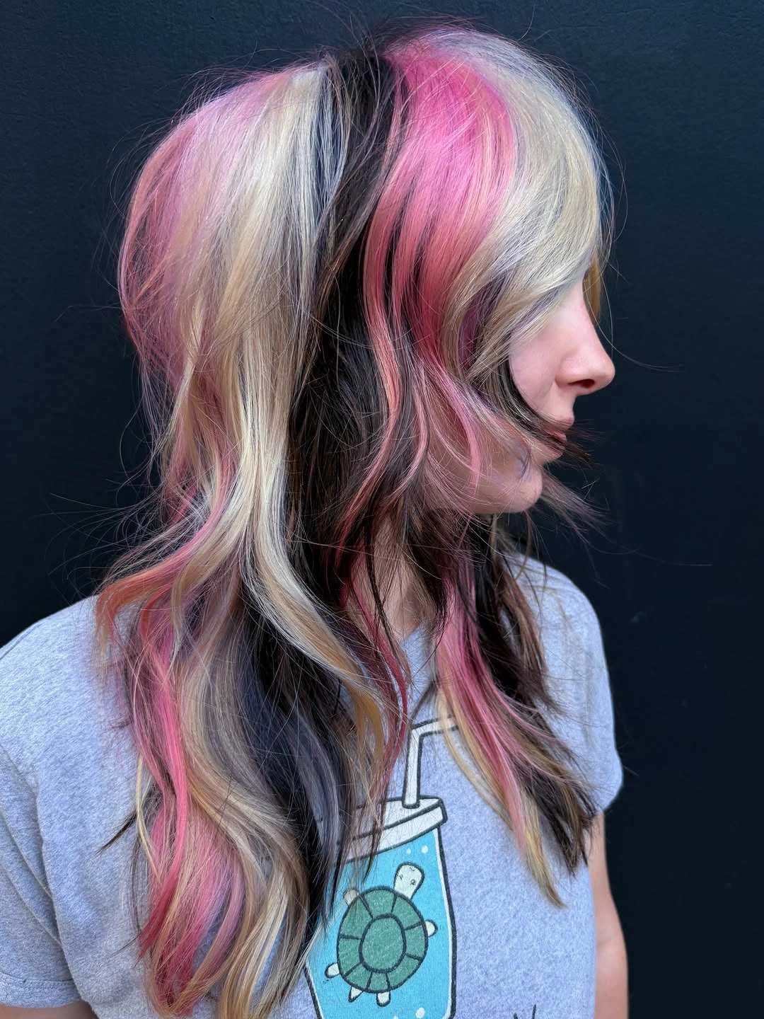 Blonde layered hair with pink streaks and dark interior pieces