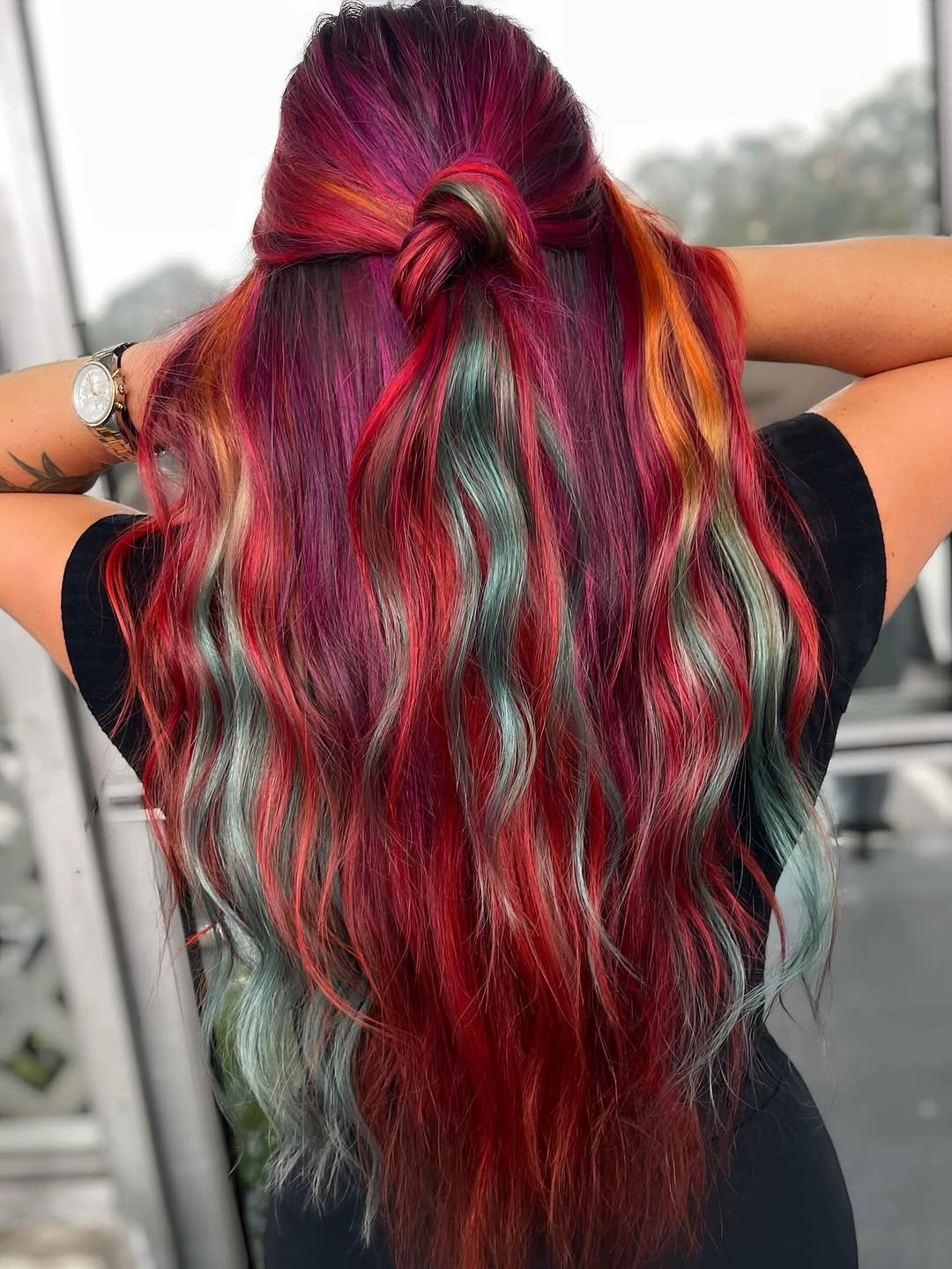 Long red waves with mint-green panels and half-up knot